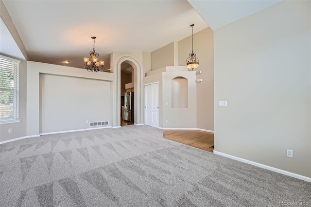 22436 E Maplewood Pl, Aurora, CO 80015 - spare room with carpet flooring, arched walkways, and a chandelier