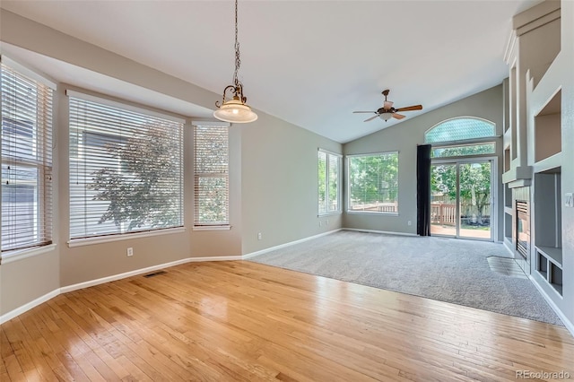 22436 E Maplewood Pl, Aurora, CO 80015 - empty room featuring light wood-style flooring, ceiling fan, vaulted ceiling, and a tiled fireplace