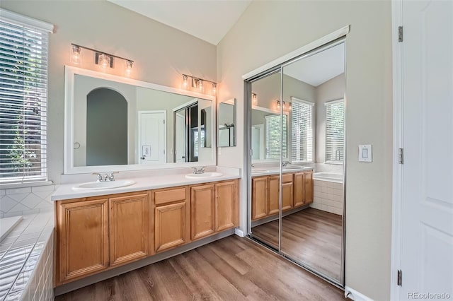 22436 E Maplewood Pl, Aurora, CO 80015 - bathroom with double vanity, wood finished floors, a garden tub, and lofted ceiling