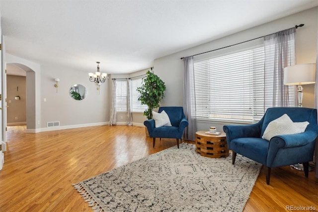 sitting room with wood-type flooring and a chandelier