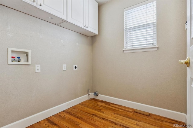 clothes washing area with cabinets, electric dryer hookup, washer hookup, and light hardwood / wood-style floors