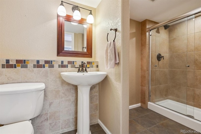 bathroom featuring walk in shower, tile walls, tile patterned floors, and toilet