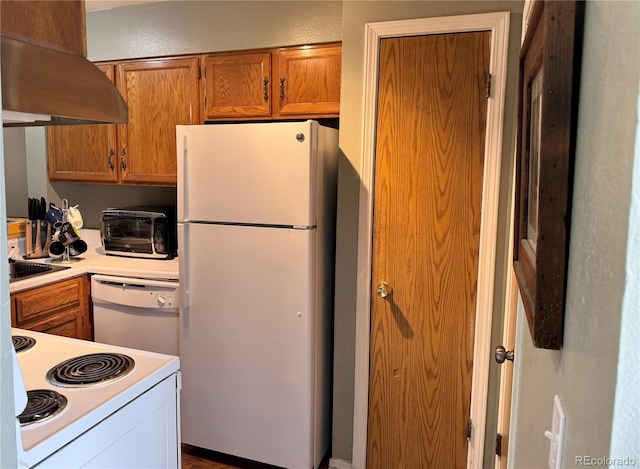kitchen featuring brown cabinets, extractor fan, light countertops, and white appliances