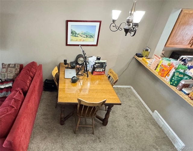 carpeted dining room featuring a chandelier and baseboards