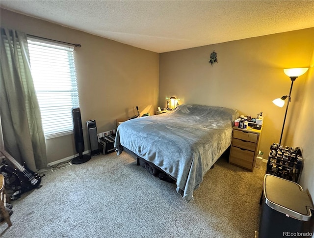 bedroom featuring carpet floors, baseboards, and a textured ceiling