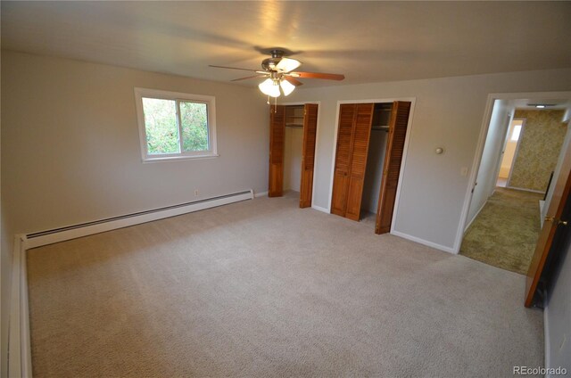 8450 Mason Cir, Westminster, CO 80031 - unfurnished bedroom with two closets, a baseboard radiator, light carpet, a ceiling fan, and baseboards