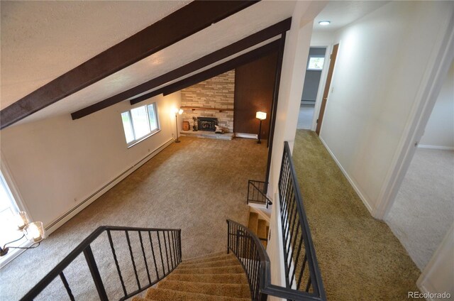 8450 Mason Cir, Westminster, CO 80031 - staircase featuring carpet flooring, baseboard heating, a stone fireplace, and baseboards