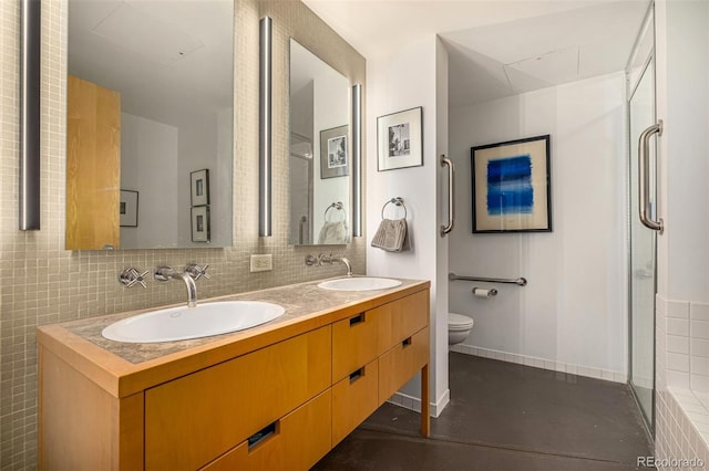 bathroom with double vanity, toilet, a shower, and a sink