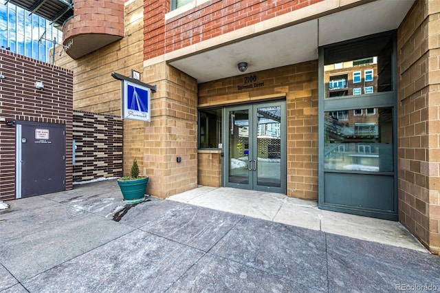 property entrance featuring brick siding and french doors