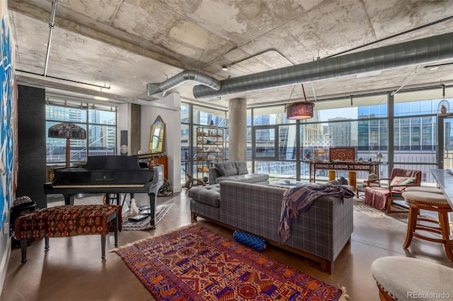 living area featuring concrete floors and decorative columns