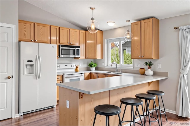 3312 Meadow Ave, Broomfield, CO 80020 - kitchen featuring white appliances, a peninsula, light countertops, wood finished floors, and vaulted ceiling