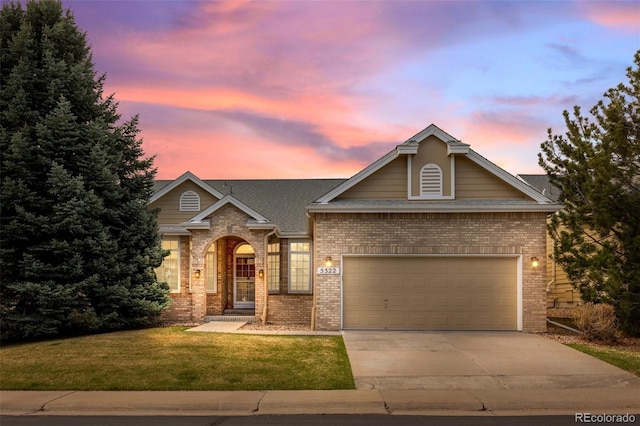 view of front of home featuring concrete driveway, brick siding, an attached garage, and a lawn