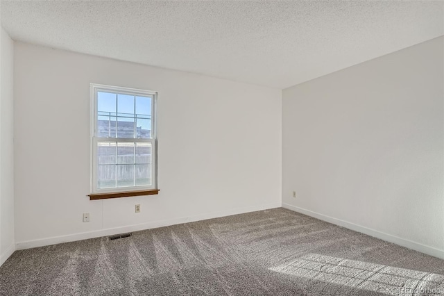 carpeted spare room featuring a textured ceiling