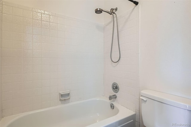 bathroom featuring toilet and tiled shower / bath