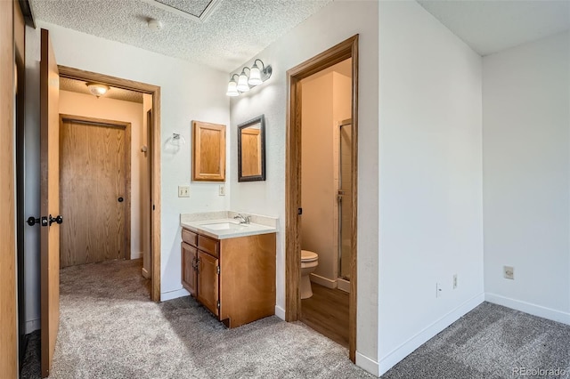 bathroom featuring vanity, a shower, toilet, and a textured ceiling