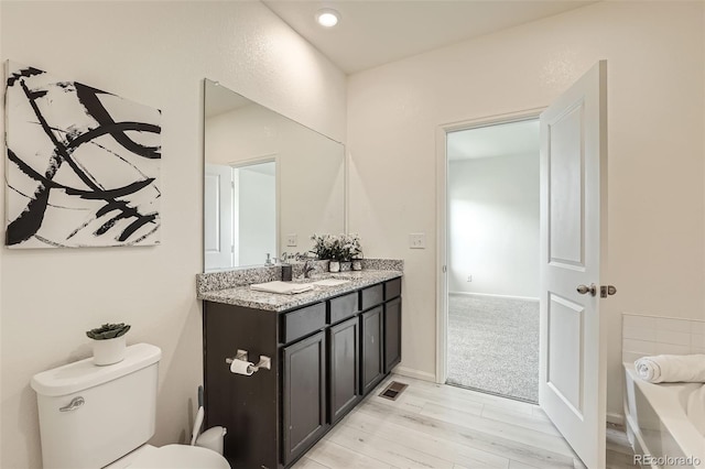 401 Quincy Rr Ave, Keenesburg, CO 80643 - bathroom with double vanity, wood finished floors, toilet, and a bathtub