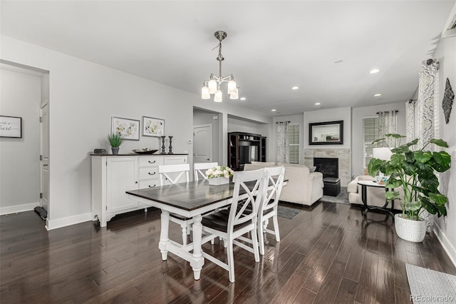 dining area featuring recessed lighting, baseboards, dark wood finished floors, and a glass covered fireplace