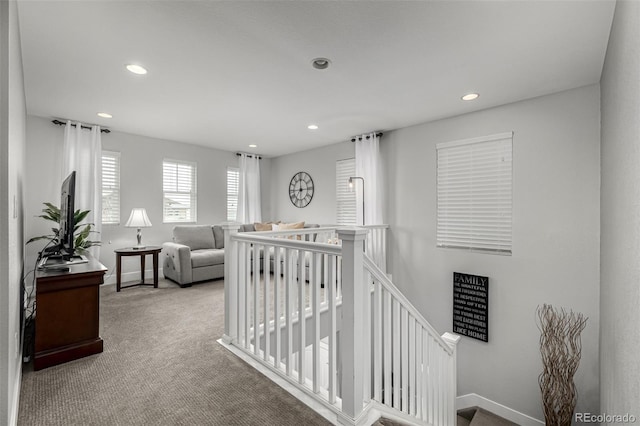 hall with baseboards, carpet floors, an upstairs landing, and recessed lighting