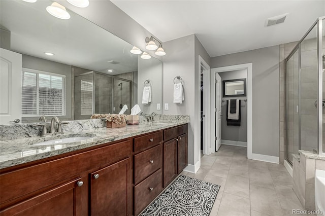 full bathroom with a stall shower, visible vents, a sink, and double vanity