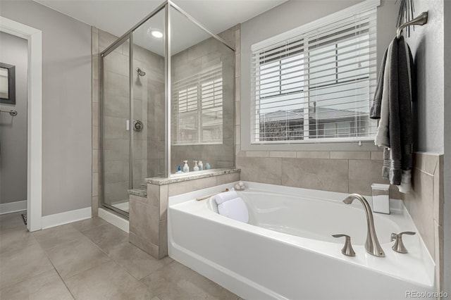 full bathroom with a garden tub, tile patterned flooring, baseboards, and a stall shower