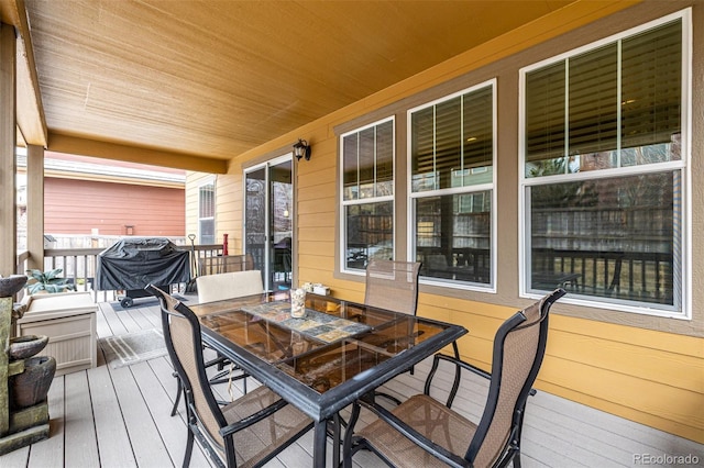 wooden terrace with outdoor dining space and grilling area