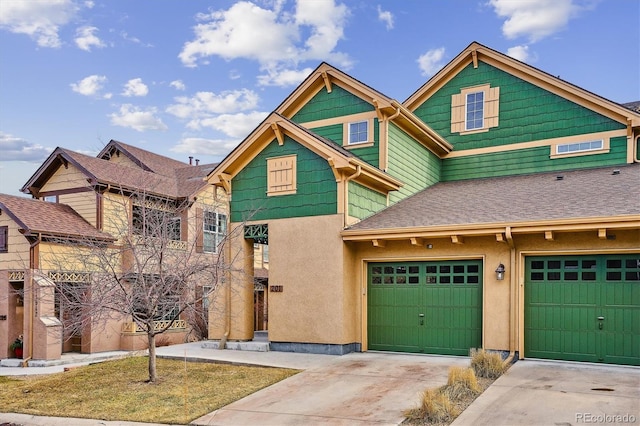 view of front of house featuring driveway, a shingled roof, an attached garage, and stucco siding