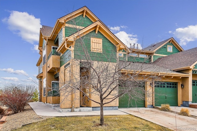 view of front of property with a garage, concrete driveway, and stucco siding