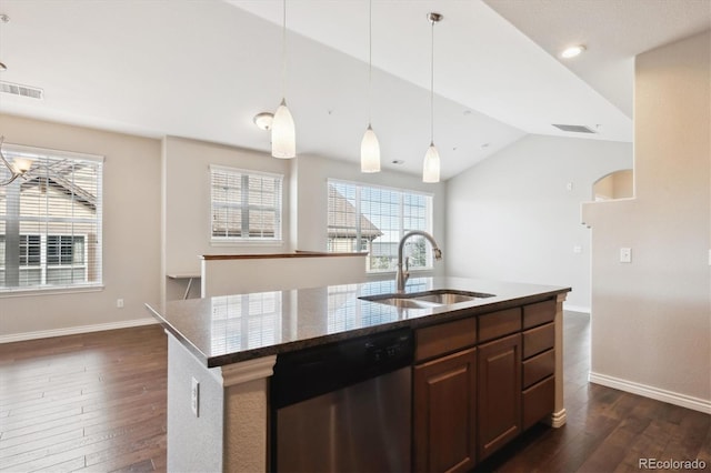 kitchen featuring sink, vaulted ceiling, hanging light fixtures, stainless steel dishwasher, and a kitchen island with sink