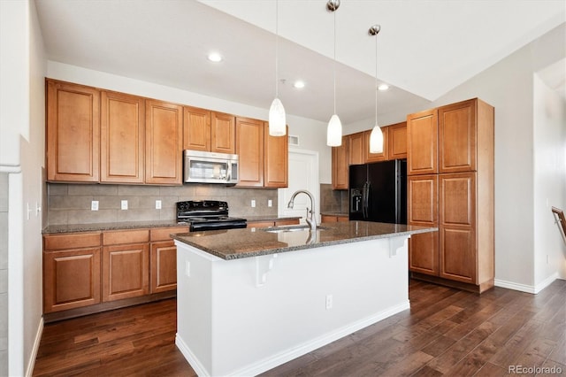 kitchen featuring tasteful backsplash, dark stone countertops, dark wood-style flooring, black appliances, and a sink