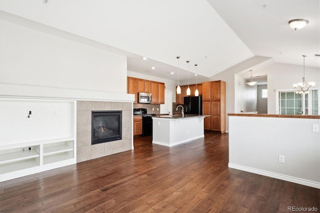 unfurnished living room featuring lofted ceiling, dark wood-style flooring, an inviting chandelier, a fireplace, and a sink