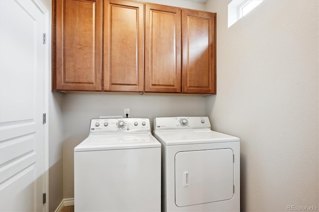 clothes washing area featuring washing machine and dryer and cabinet space