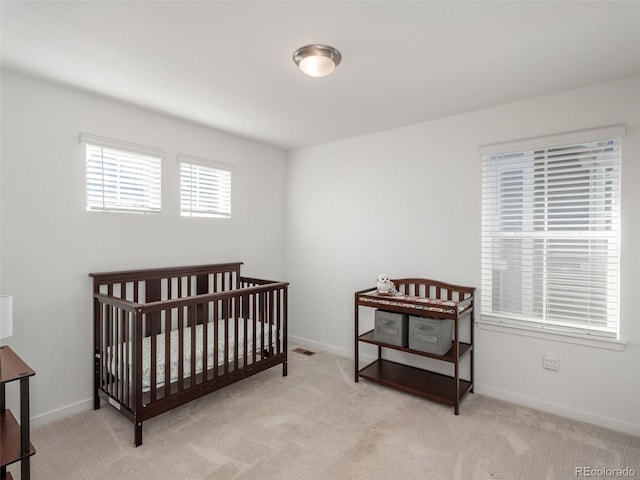 carpeted bedroom featuring a crib