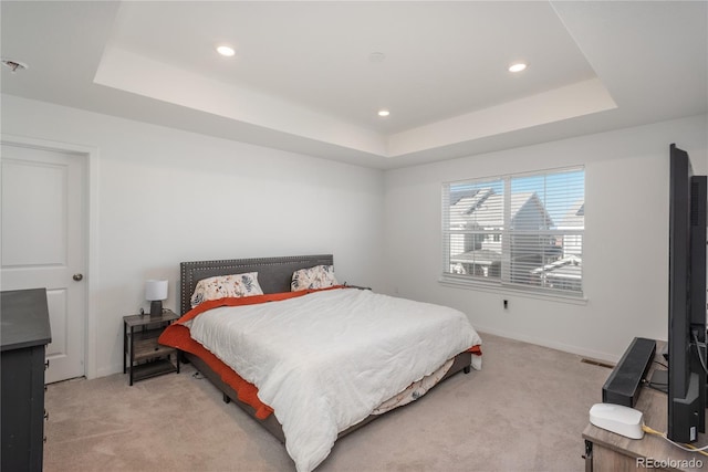 carpeted bedroom with a tray ceiling