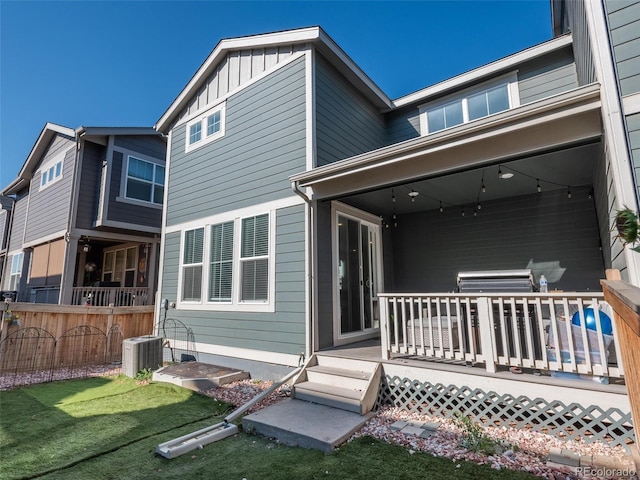 rear view of house featuring a yard, a wooden deck, and central AC