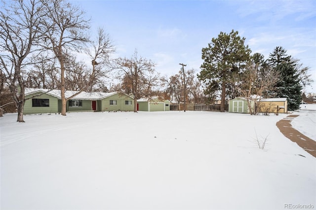 yard covered in snow with a shed