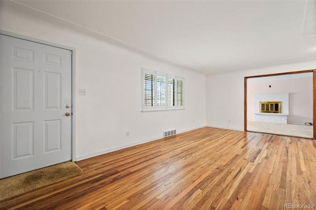 unfurnished living room featuring wood-type flooring and a fireplace