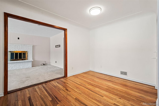 unfurnished living room with a fireplace and hardwood / wood-style floors