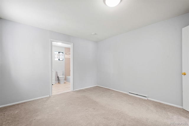 spare room featuring a baseboard radiator and light colored carpet