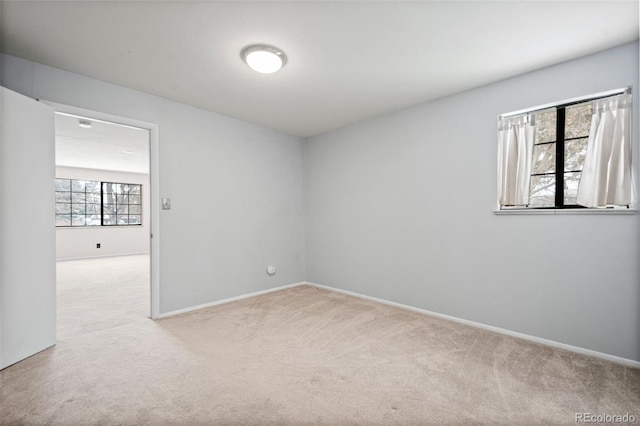 carpeted spare room featuring a wealth of natural light