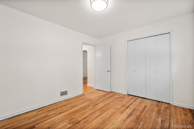 unfurnished bedroom featuring light hardwood / wood-style flooring and a closet