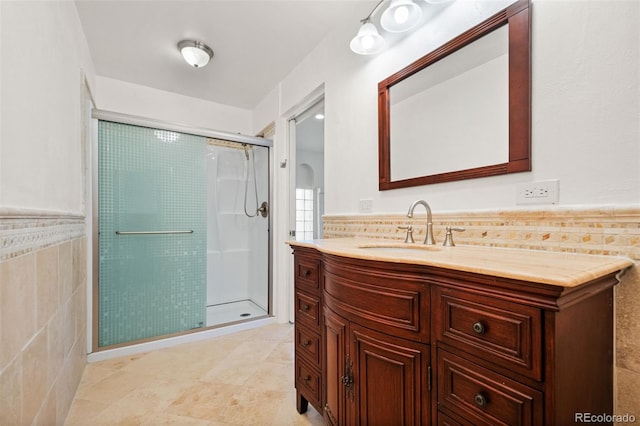 bathroom featuring vanity, walk in shower, and tile walls