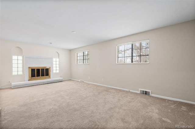 unfurnished living room featuring light carpet and baseboard heating