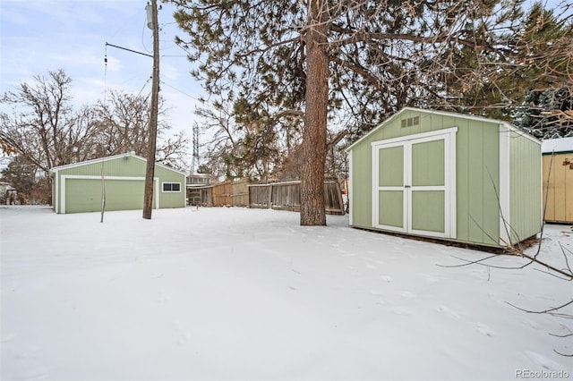 yard layered in snow with a storage unit