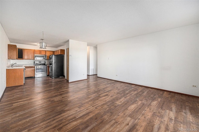 kitchen with sink, stainless steel appliances, dark hardwood / wood-style floors, and a textured ceiling