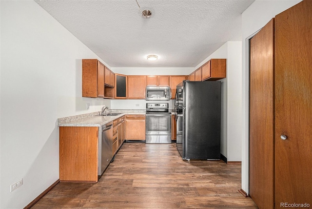 kitchen featuring sink, stainless steel appliances, dark hardwood / wood-style floors, and a textured ceiling