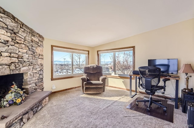 office area with a stone fireplace and carpet