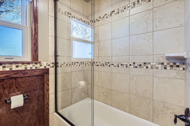 bathroom featuring bath / shower combo with glass door