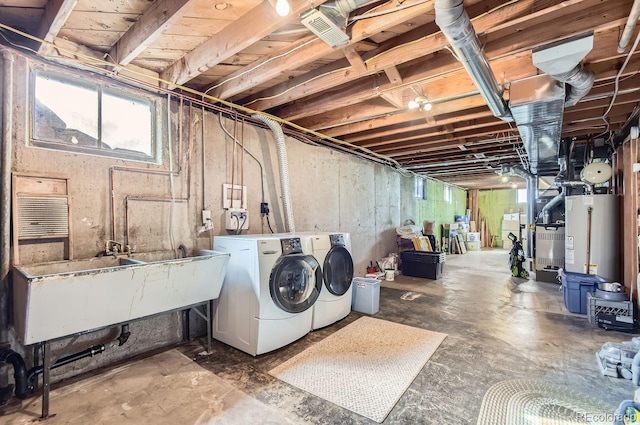 laundry area featuring water heater, sink, and washer and dryer