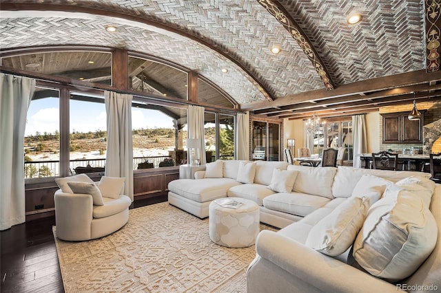 living room featuring an inviting chandelier, light hardwood / wood-style flooring, and brick ceiling