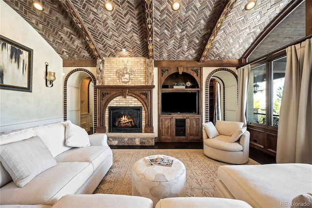 living room with brick ceiling, lofted ceiling, a fireplace, and built in shelves